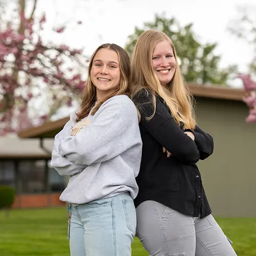 ASLU-PC President Brielle Brick, left, and Vice President Violet Strange, right, stand back-to-back on the Portland campus.