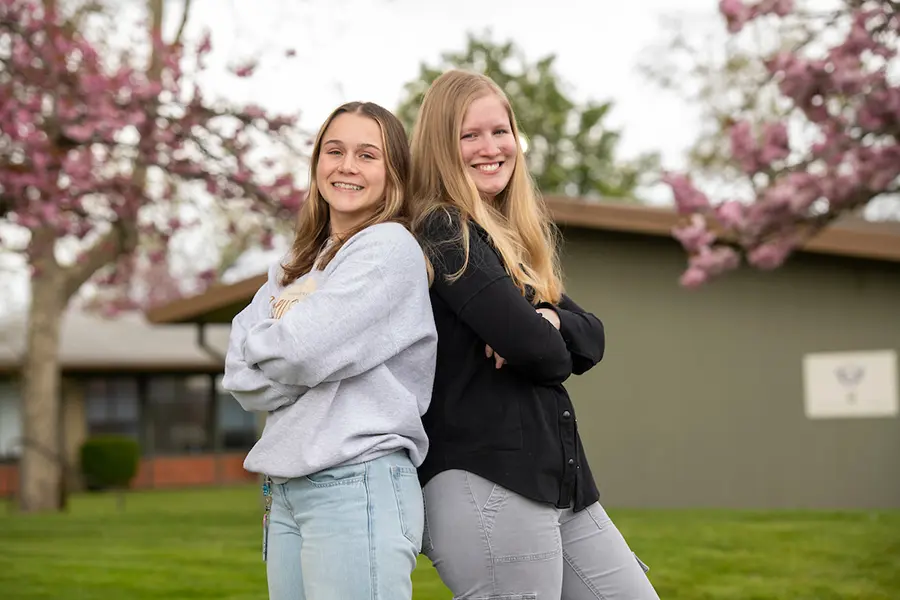 ASLU-PC President Brielle Brick, left, and Vice President Violet Strange, right, stand back-to-back on the Portland campus.