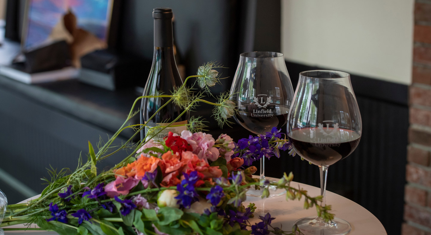 A table in Acorn to Oak with a bottle of red wine next to two wine glasses.