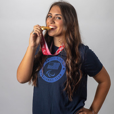 Annie Flood '25 biting her gold medal