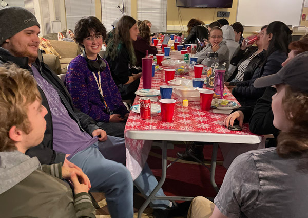 LUP members sitting around a table talking and sharing a meal together.