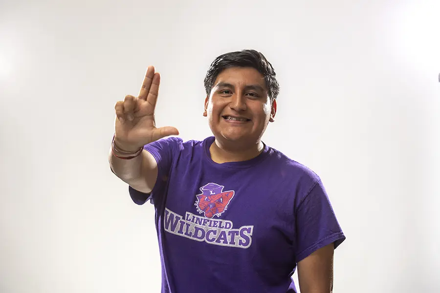 Ivan in a Linfield shirt making the Linfield L with his hand.