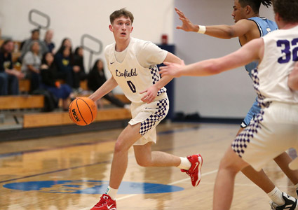 Jake Downing dribbling the basketball on the court during a basketball game.