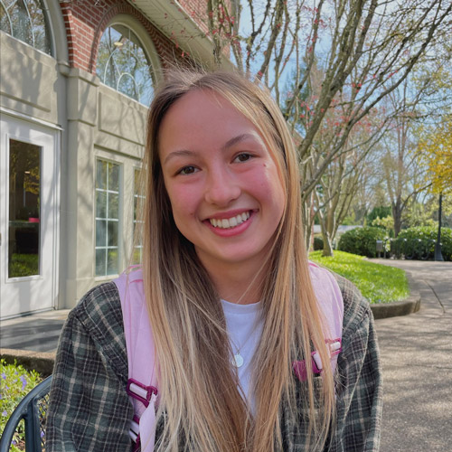 Lucy Kerr '24 sitting down outside of Starbucks, smiling