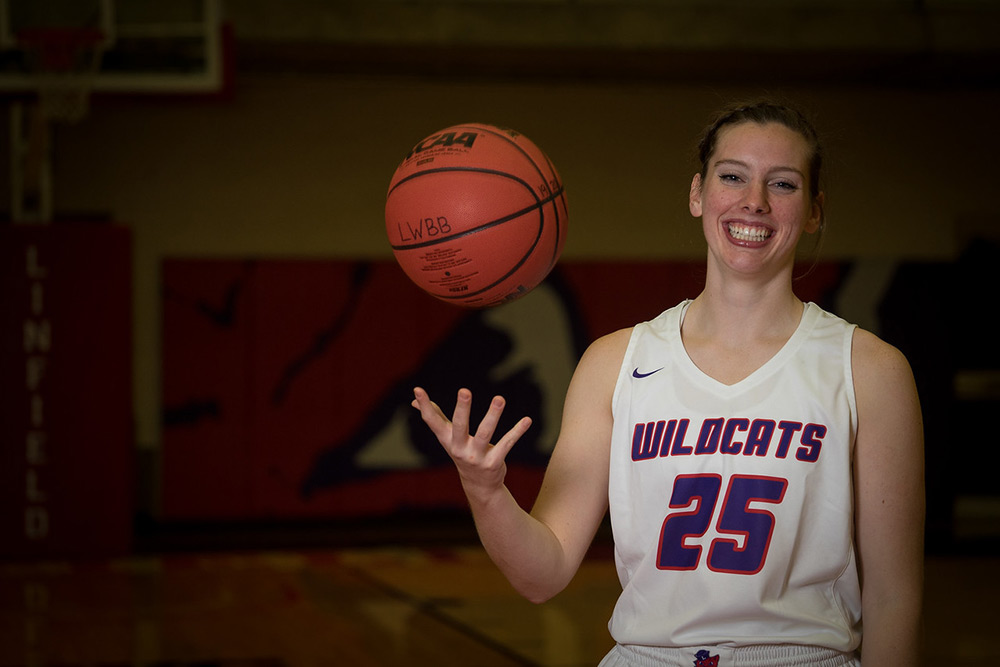 Molly in uniform tossing basketball in the air