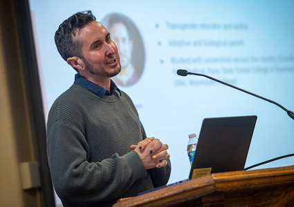 Trystan speaking behind a podium during the faculty resilience training session at Linfield