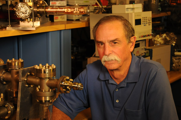 David Wineland next to a piece of equipment.