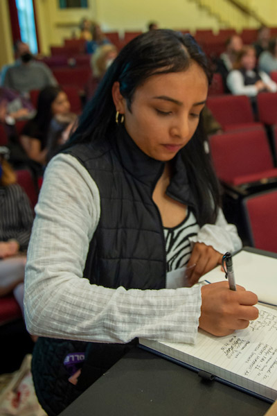 student signing the book at the first Alpha Alpha Alpha Honors Society induction