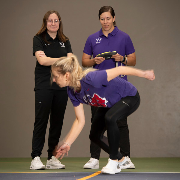 Two students working with a student-athlete in an HHPA lab.