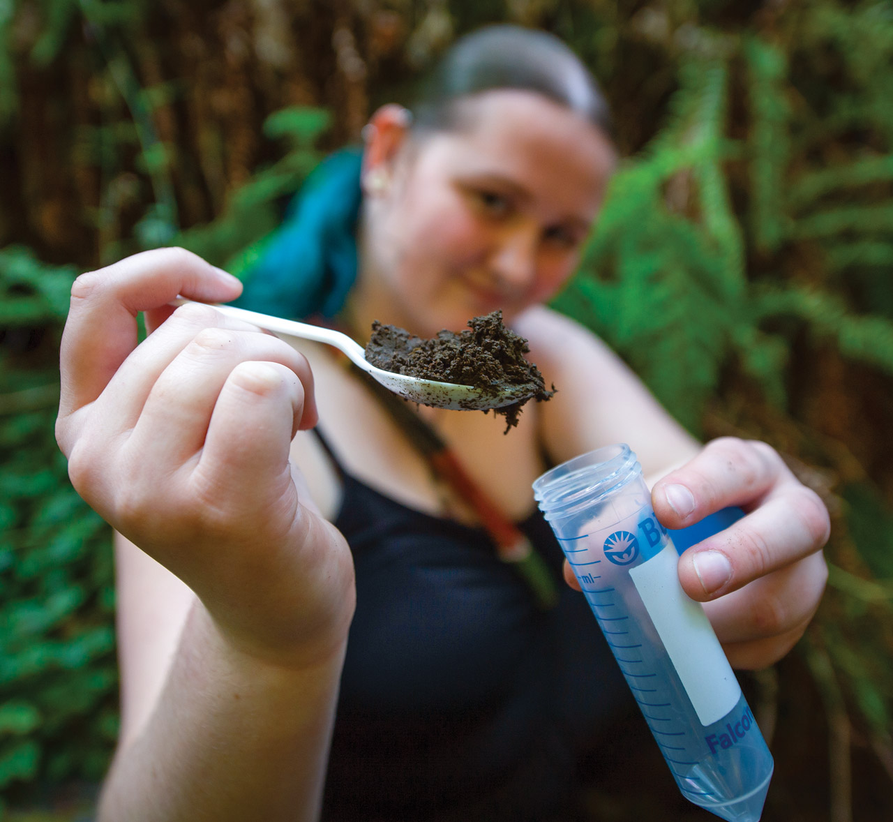 Female student taking a dirt sample.