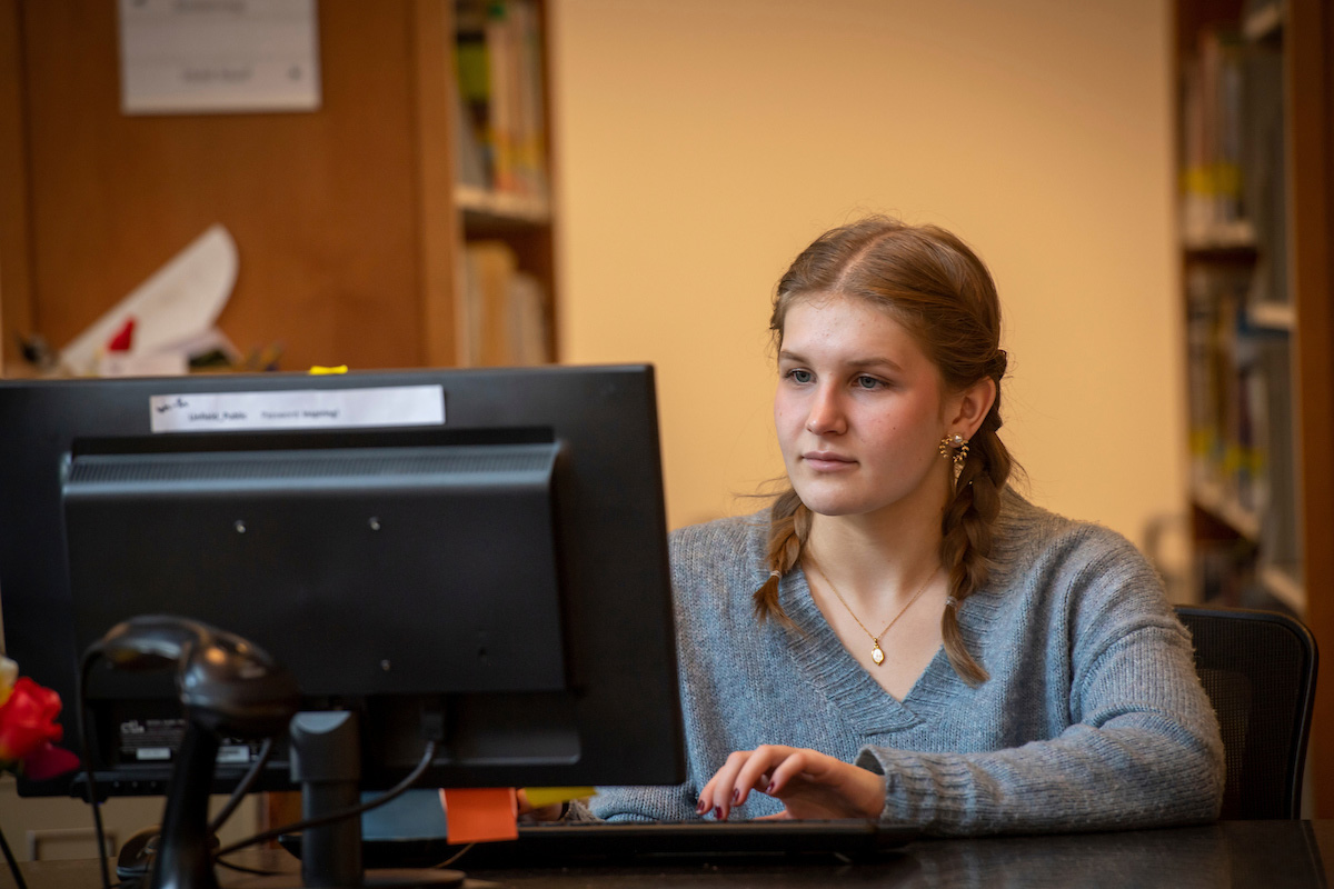 Student works at library behind computer