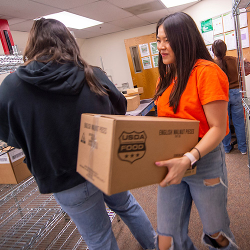 students stocking the shelves at the food pantry.