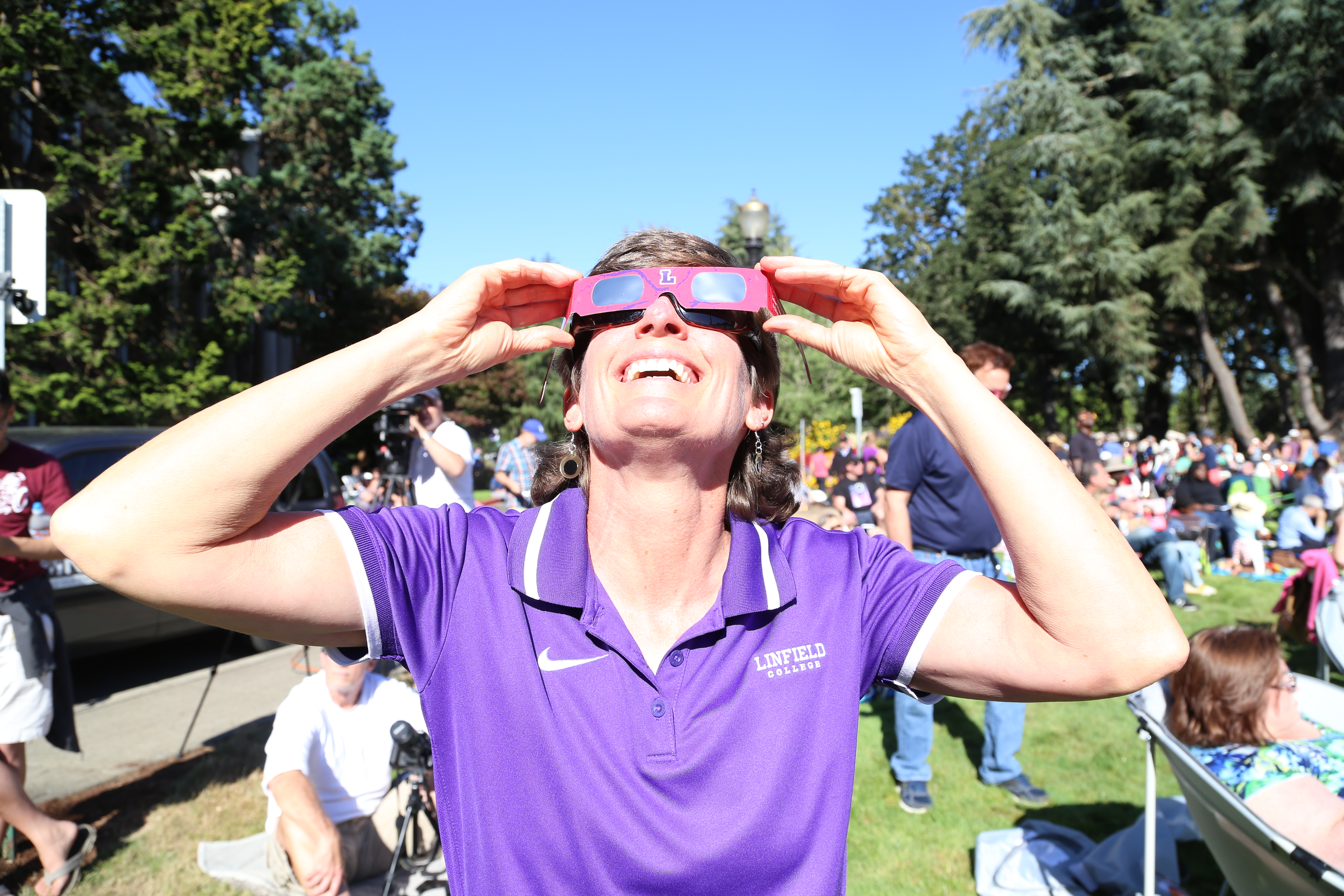 Observer looks at solar eclipse through glasses