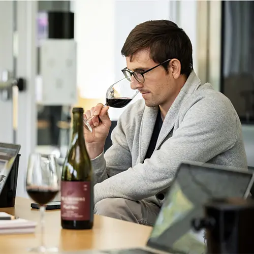 a student examining a glass of wine during a class.